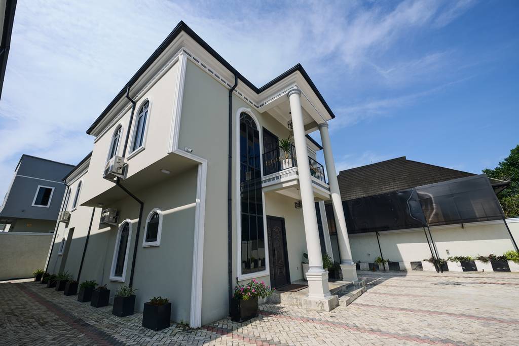 The 1% Manor exterior with its double-height entrance and paved courtyard